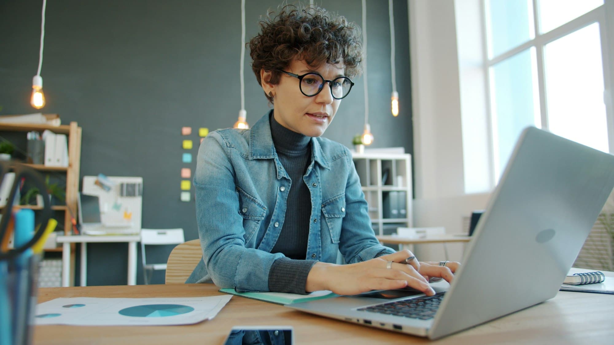 A professional working at a laptop in a bright modern office